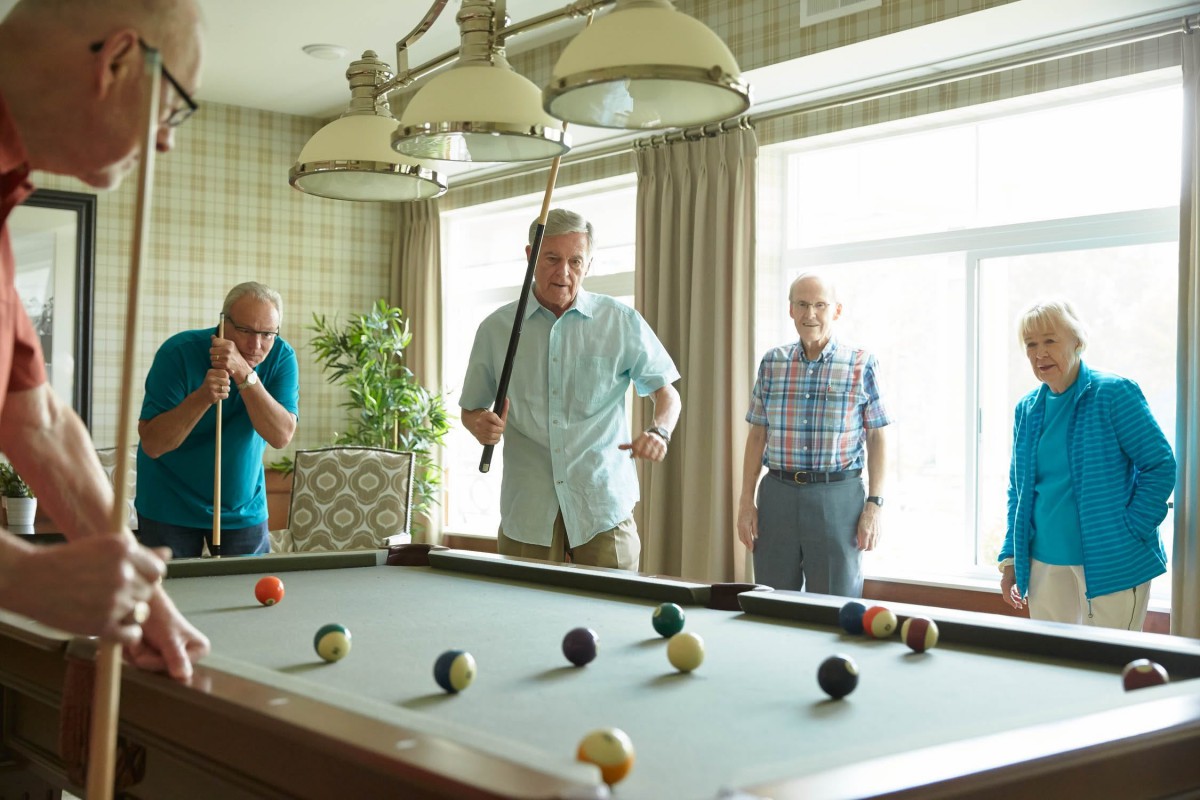 A group of people enjoying a game of billiards in a cozy game room.