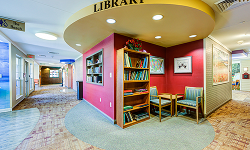 A cozy library corner with bookshelves and seating for reading.