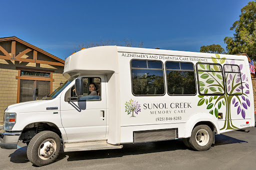 A community service bus from Sunol Creek parked under a clear blue sky.