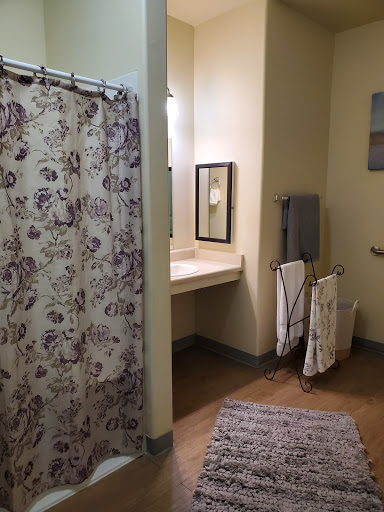A cozy bathroom featuring a floral shower curtain and neatly arranged towels.
