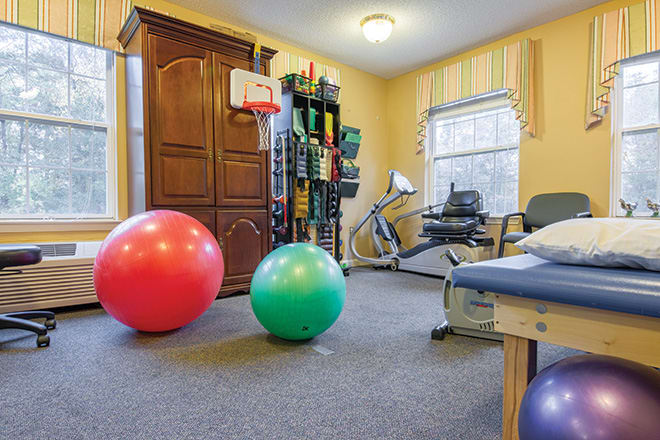 A therapy room equipped with exercise balls and a stationary bike for fitness and rehabilitation activities.