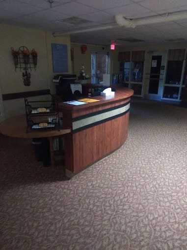 A dimly lit office reception area with a wooden desk.