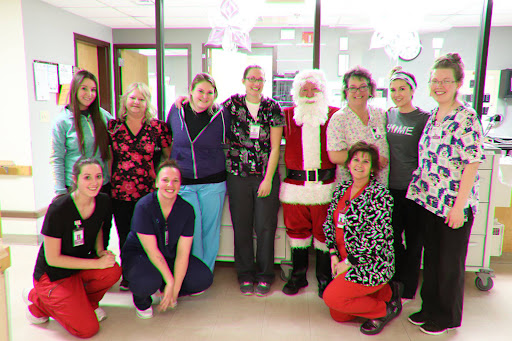 Healthcare staff celebrating the holiday season with Santa Claus.