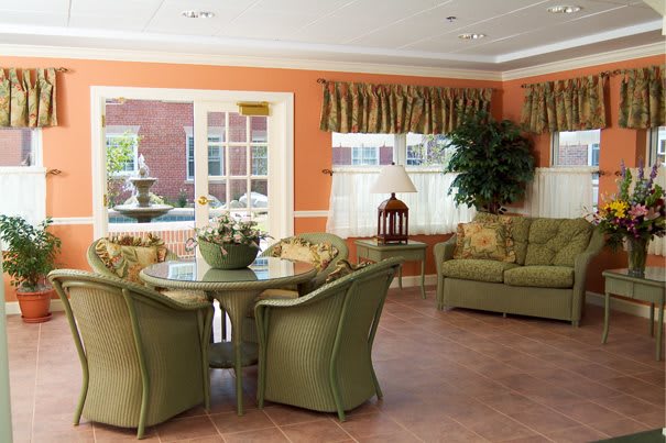 A warm and inviting living room with green furniture and large windows.