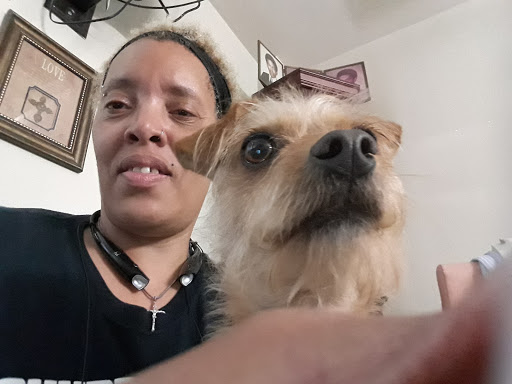 A person taking a selfie with their dog, both looking at the camera.