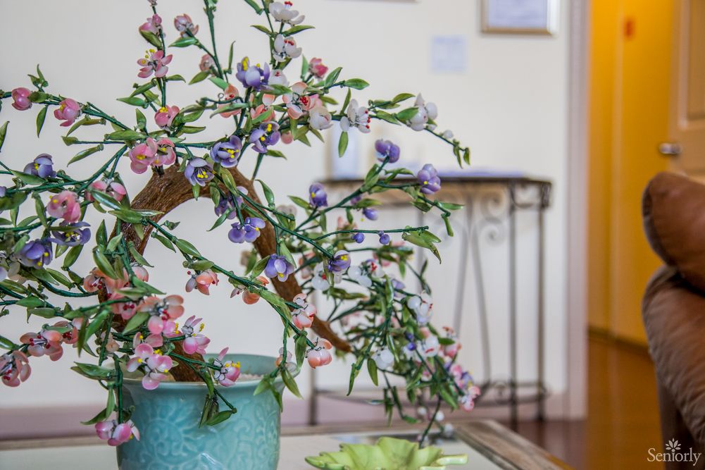 A decorative arrangement of colorful artificial flowers in a ceramic pot indoors.