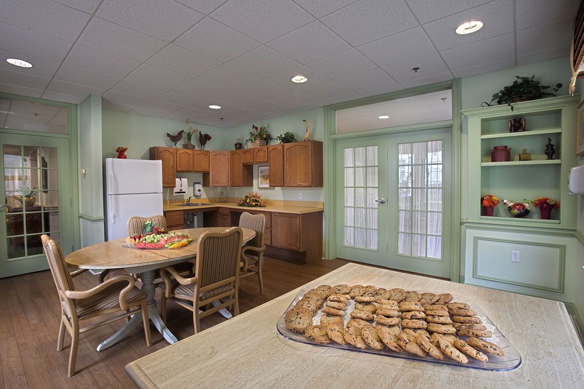 A cozy kitchen setup with cookies on the table and wooden cabinets.