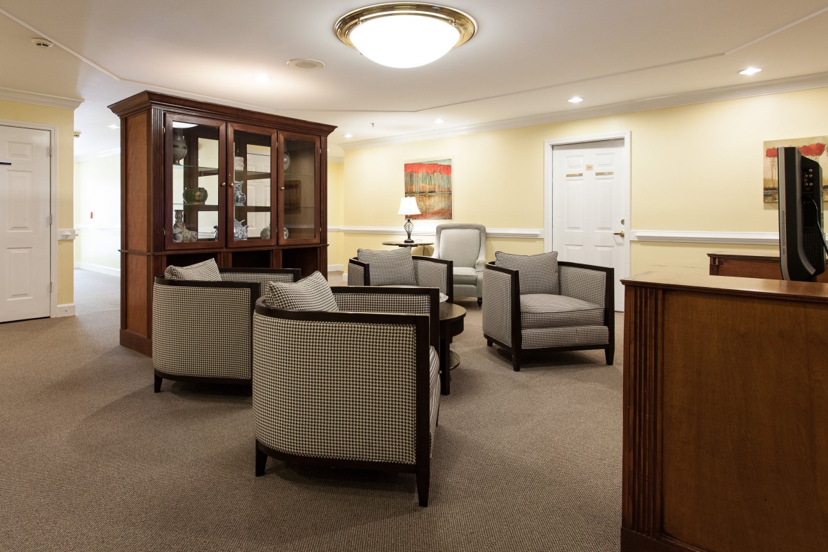 A cozy lobby or waiting area with armchairs and a cabinet.