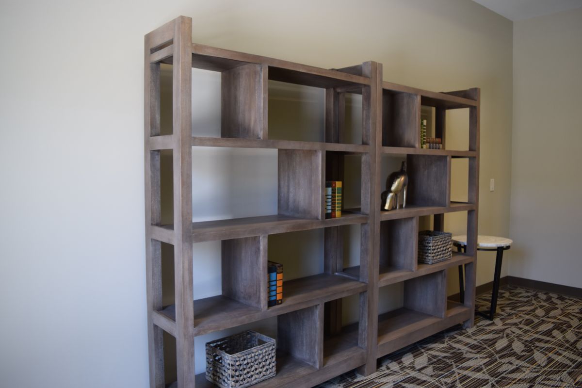A modern wooden bookshelf with a mix of books and decorative items displayed.