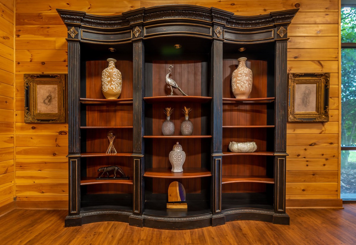 An elegant black and wooden bookshelf with decorative vases and artifacts.