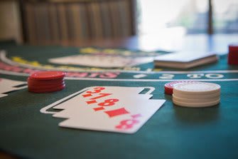 Close-up of a poker game with playing cards and chips on a casino table.