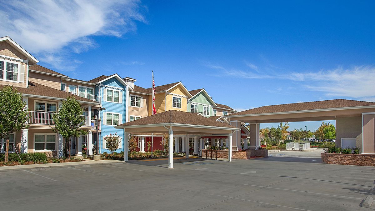 A colorful and modern residential building with an entrance drive-through.