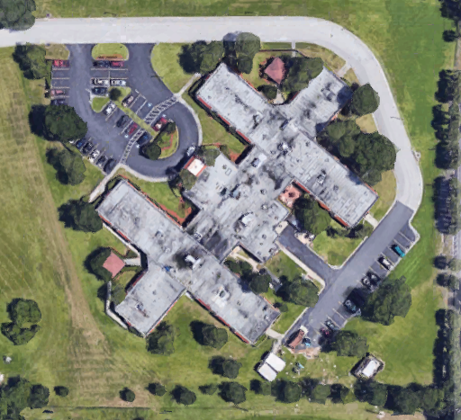 Aerial view of a complex featuring multiple wings and surrounded by landscaped areas.