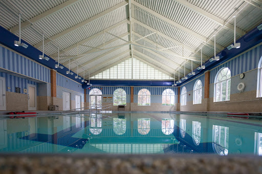 A serene indoor swimming pool reflecting the architectural beauty of its surroundings.