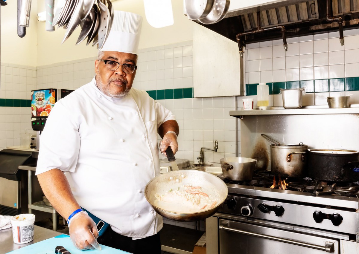 A chef cooking in a professional kitchen.