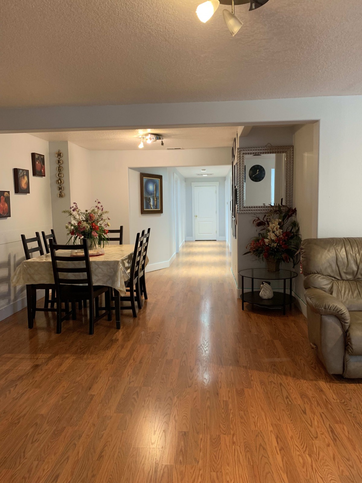 Spacious open-plan dining and living area with wooden flooring and cozy furnishings.
