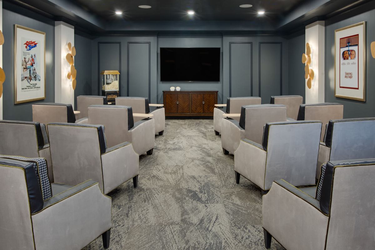 A luxurious home theater with comfortable seating and a large screen.