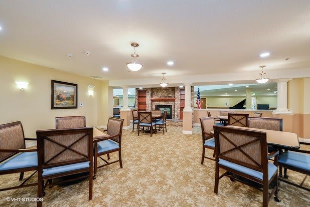 A cozy seating area with tables and chairs, complemented by warm lighting and decor.