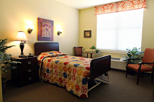 A cozy and colorful bedroom showcasing a single bed with a vibrant quilt, complemented by soft lighting and decorative elements.