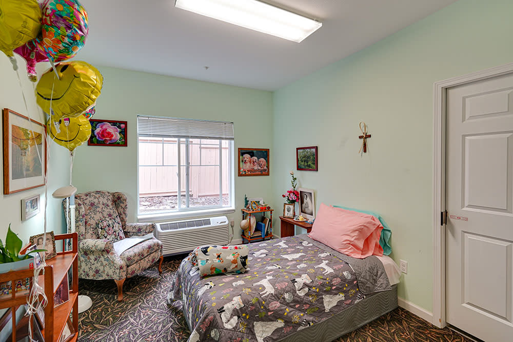 A cozy bedroom with a single bed, armchair, and decorative elements.