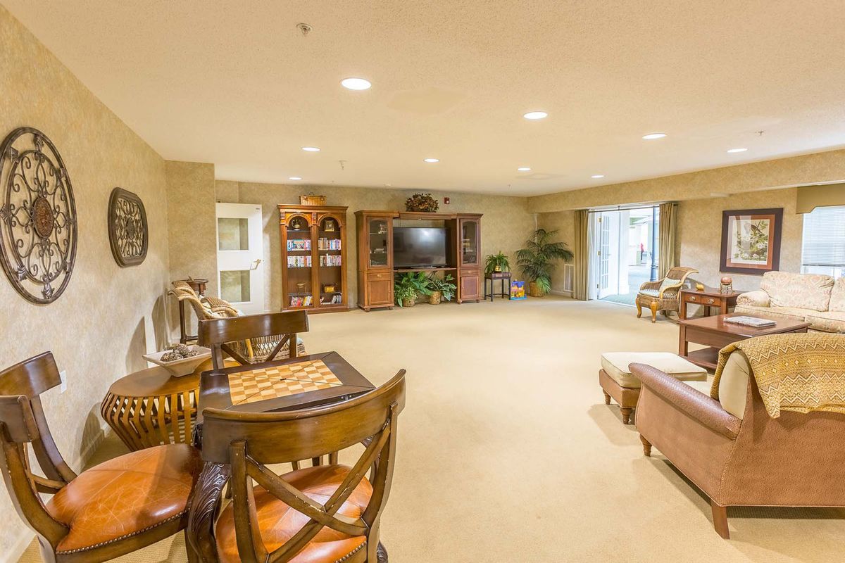 A spacious basement living area with an entertainment center and chessboard.
