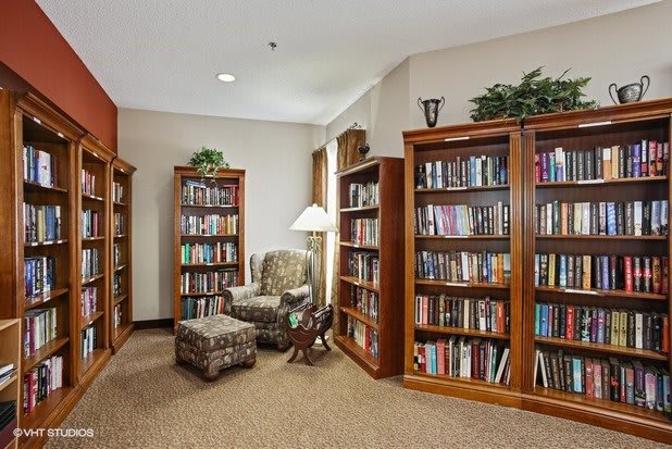 A cozy library corner with wooden bookshelves and a comfortable armchair.