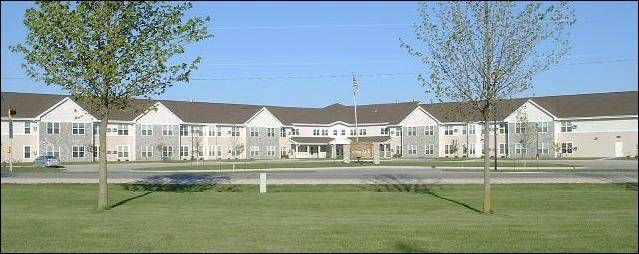 A suburban residential building with a well-maintained lawn and a clear blue sky.
