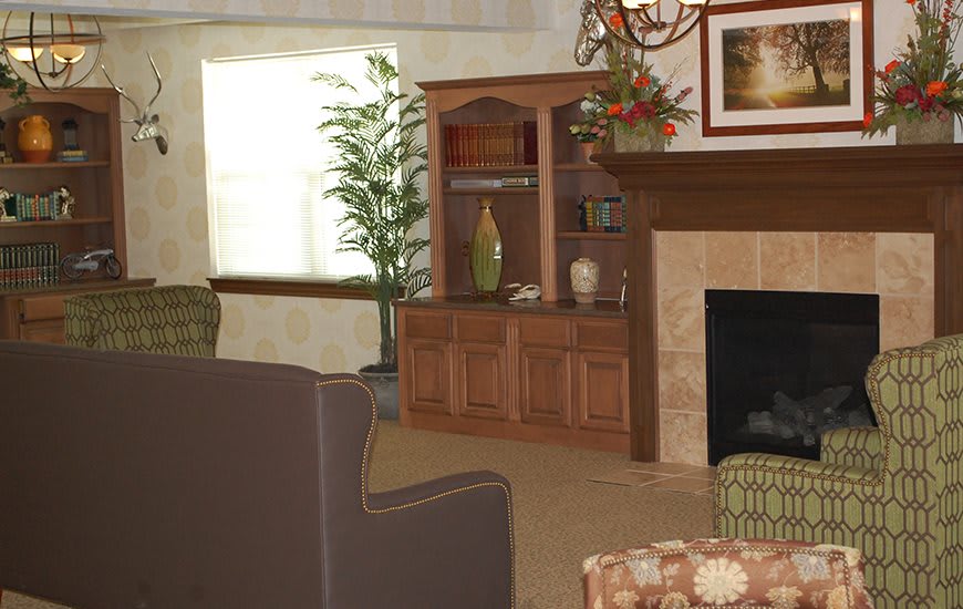 A cozy living room featuring a fireplace, bookshelf, and comfortable seating.