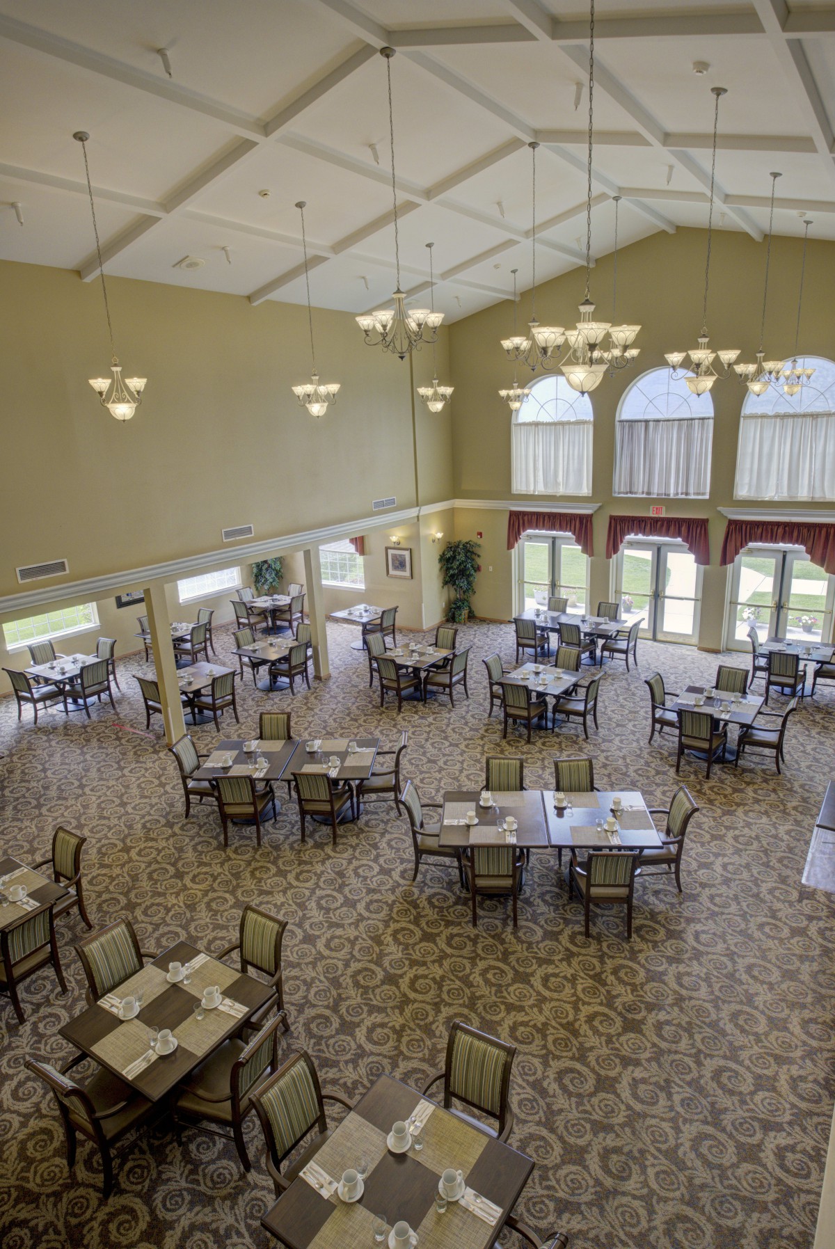 Spacious dining hall with elegantly arranged tables and large windows.