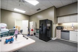 A small office kitchen with a refrigerator, microwave, and cabinets.