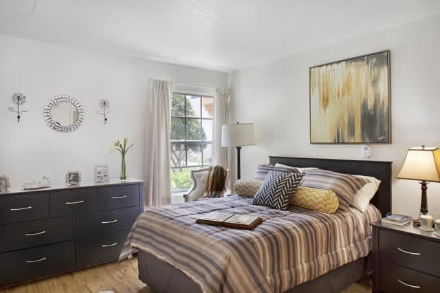 A modern bedroom with stylish decor and a large window letting in natural light.