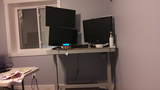 A modern home office setup featuring multiple monitors on a sleek desk.