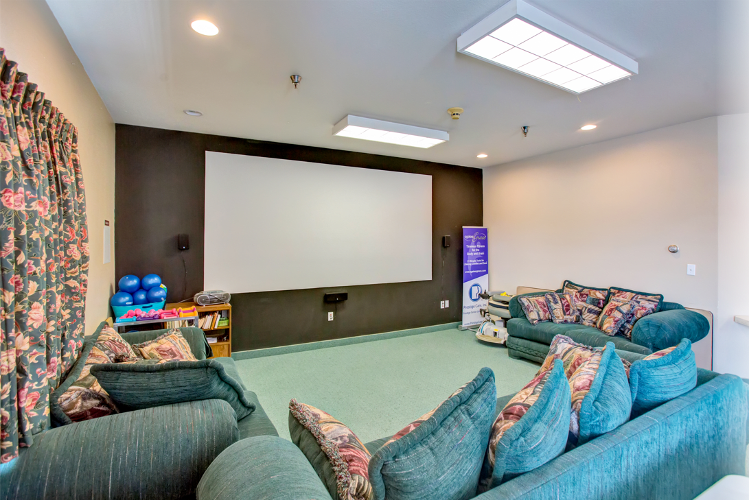 A cozy home theater with comfortable seating and a large projector screen.