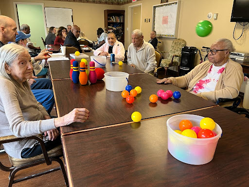 Seniors engaging in a recreational activity with colorful balls at a community center.
