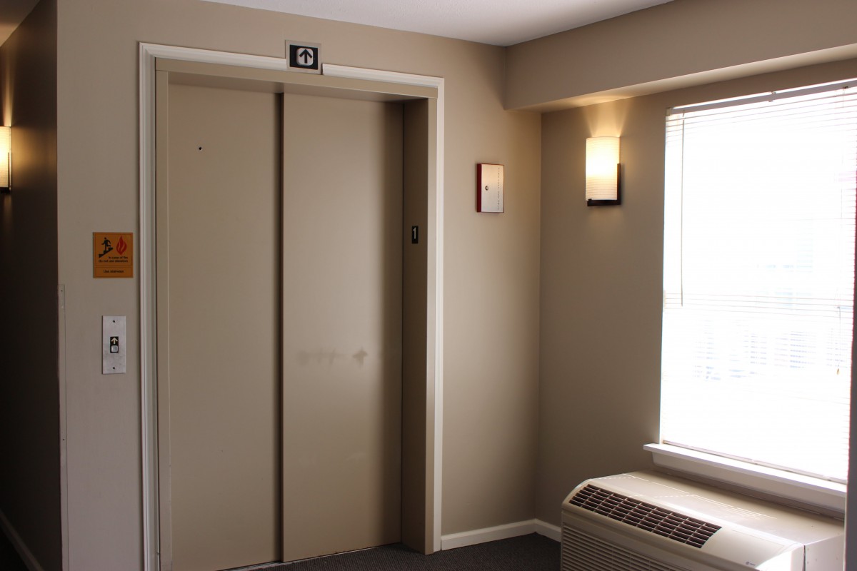 An interior view of a hallway featuring an elevator with closed doors.