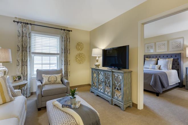 A cozy living room with an armchair, TV stand, and decorative elements.