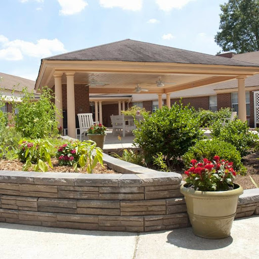 A well-maintained garden area with vibrant flowers and greenery, featuring a comfortable outdoor space.