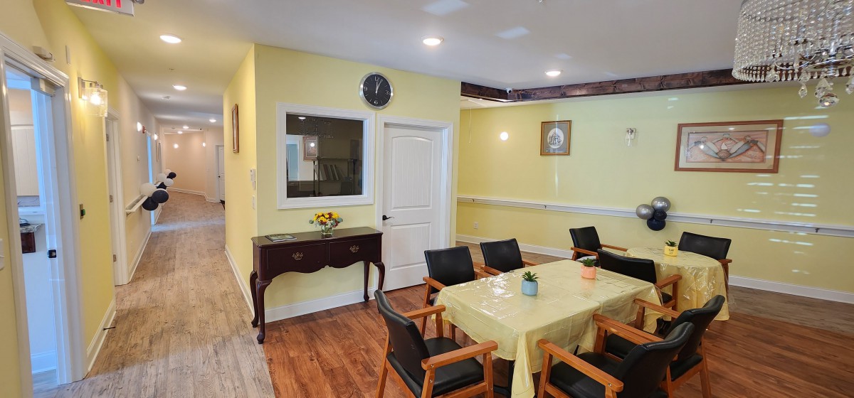 A cozy dining area with yellow walls and a wooden floor.