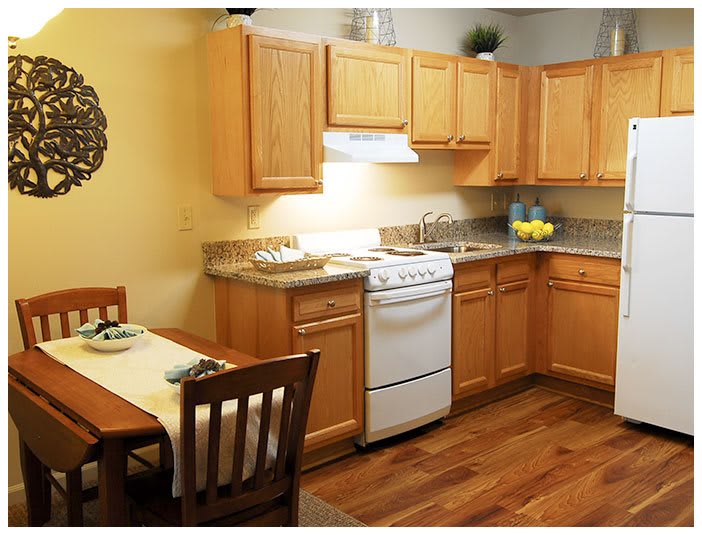 A cozy kitchen with wooden cabinets and a small dining area.