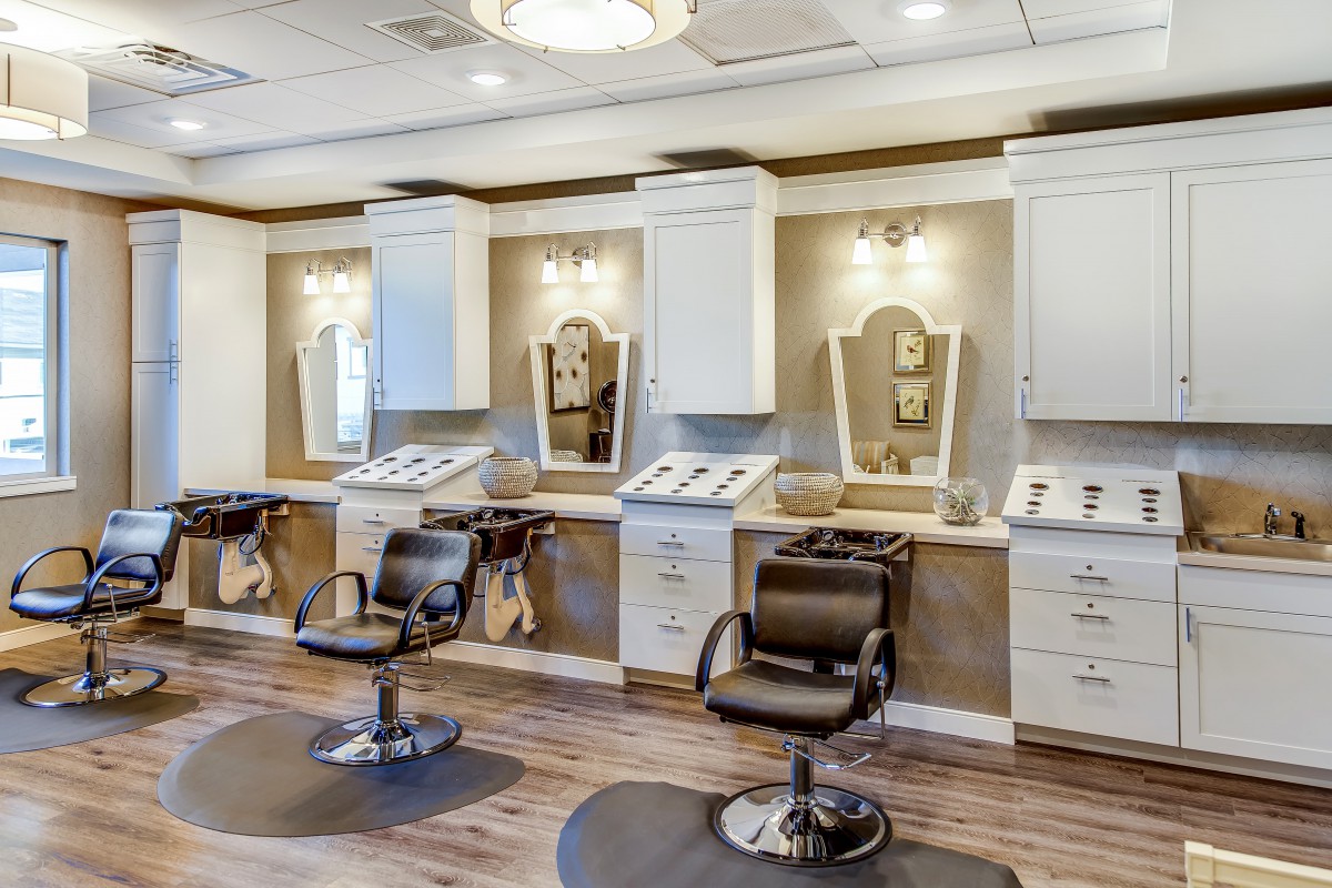 A modern beauty salon interior with styling chairs and mirrors.
