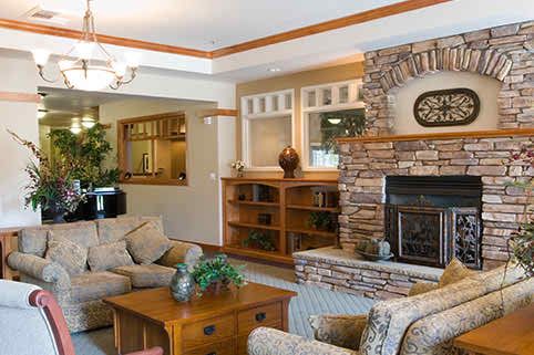 A cozy living room featuring a stone fireplace, comfortable seating, and wood accents.