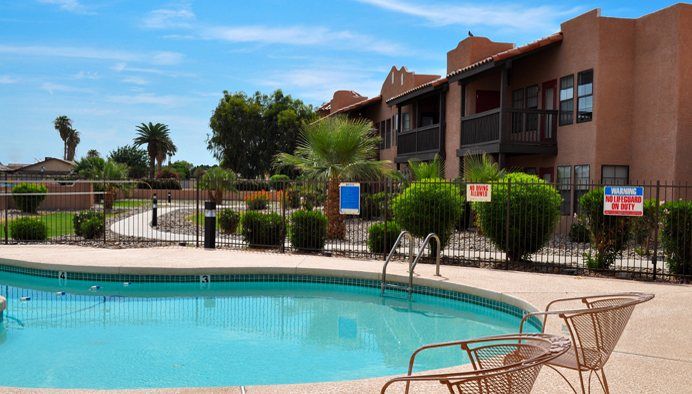 A tranquil swimming pool in a residential apartment complex on a sunny day.