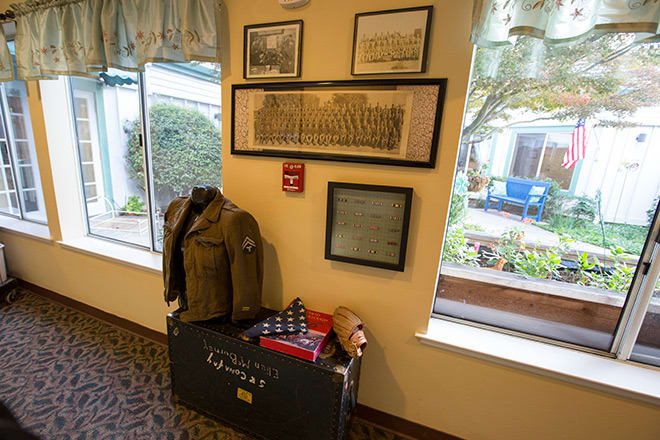 A display featuring a vintage military uniform and memorabilia, accompanied by framed historical photographs on the wall.