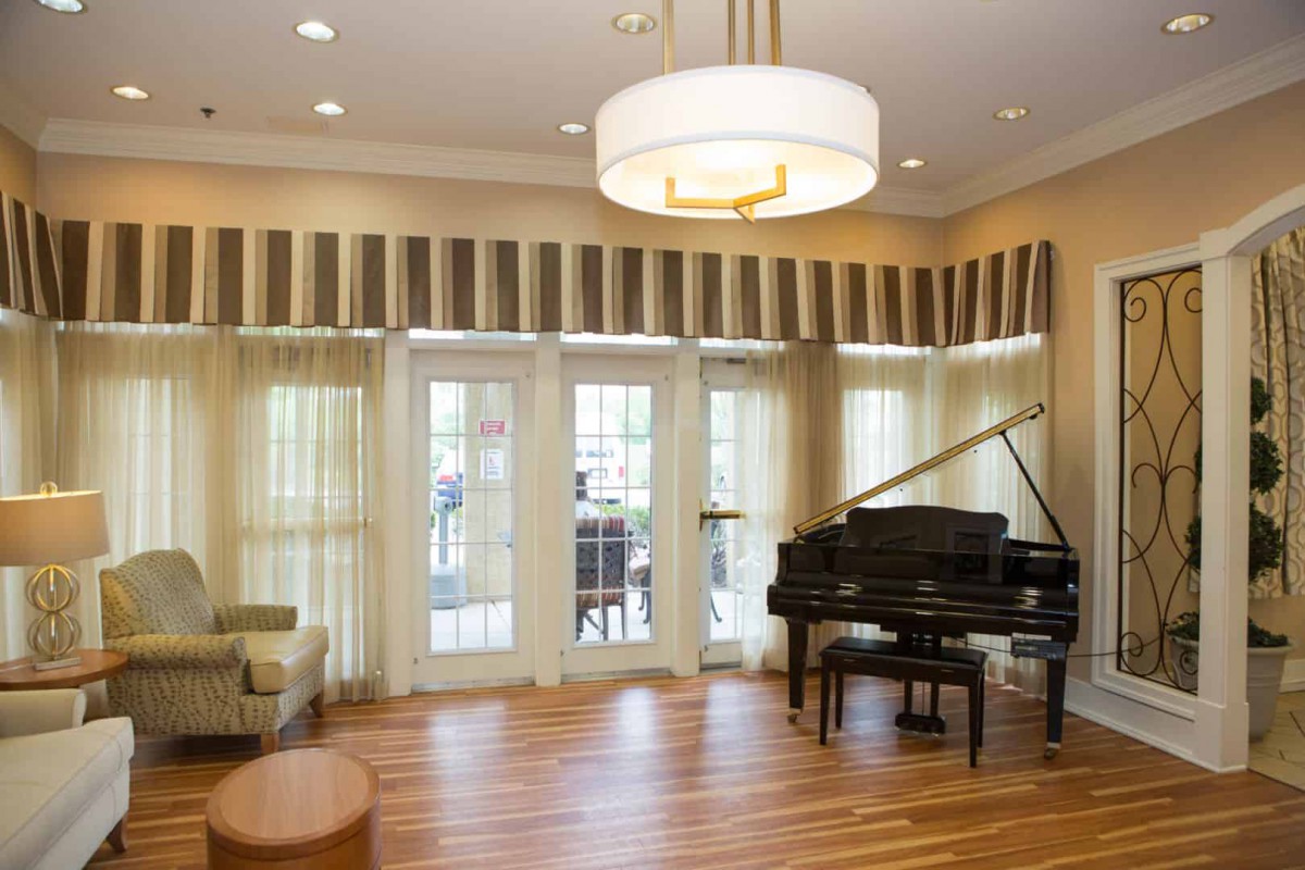 A cozy living room with a grand piano and elegant lighting.