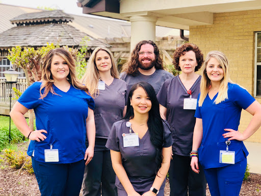 A dedicated healthcare team posing together outside.
