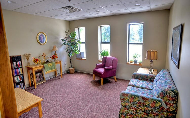 A cozy living room with comfortable seating and natural light from multiple windows.