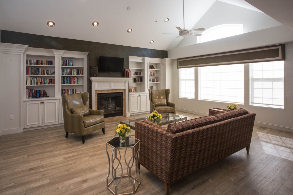 A cozy living room with a fireplace, armchairs, and a sofa.