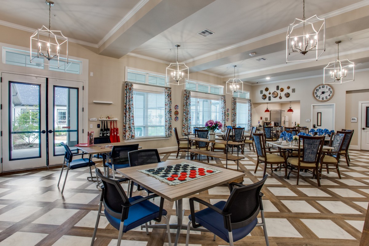 A modern game room with tables set up for checkers and ample seating.