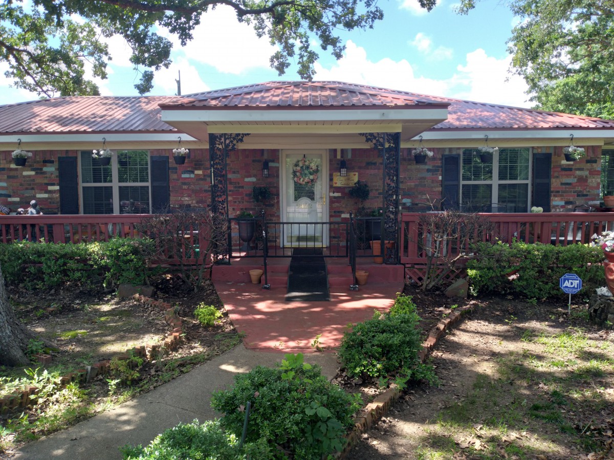 A charming brick house with a welcoming front porch and well-maintained landscaping.