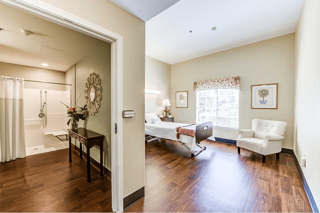 A well-lit hospital room featuring a patient bed and comfortable seating, designed to provide a welcoming atmosphere.
